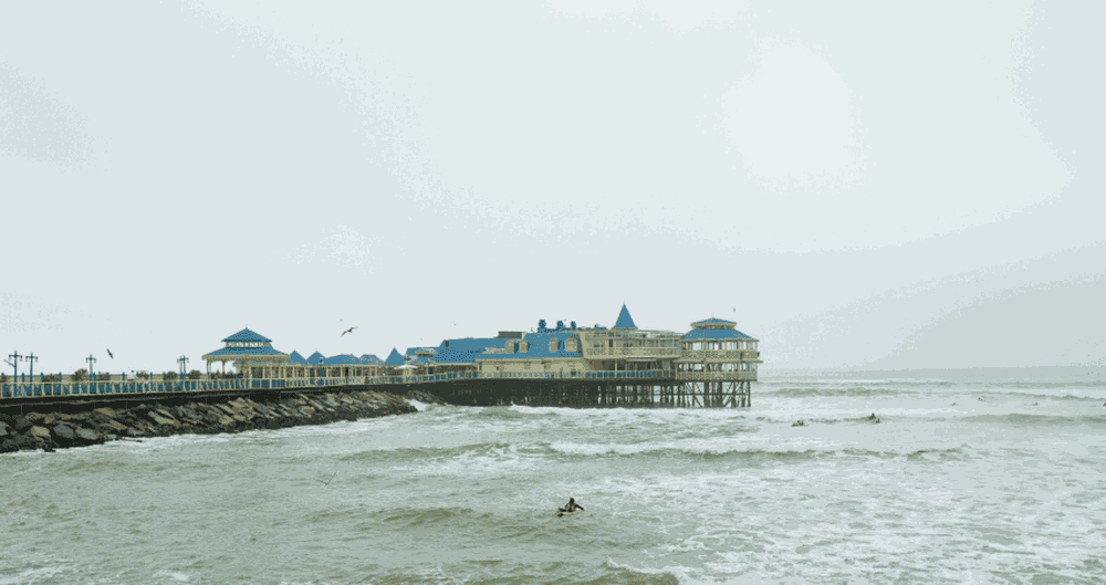 Ein Surfer vor dem Rosa Nautica an der Küste von Miraflores.