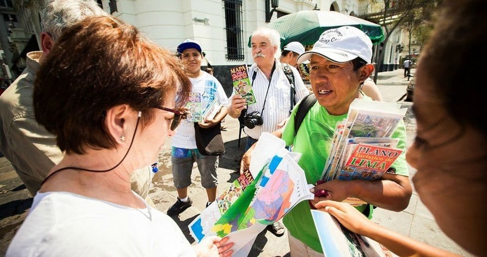 Lerne Spanisch auf deiner Südamerikareise. Die Reisegruppe fragt eine Peruanerin nach dem Weg.